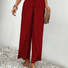 Red wide-leg trousers with shirred waist, flowing wide leg, repeating micro pattern.