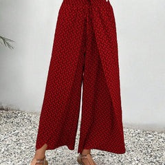 Red wide-leg trousers with shirred waist, repeating micro pattern, full length.