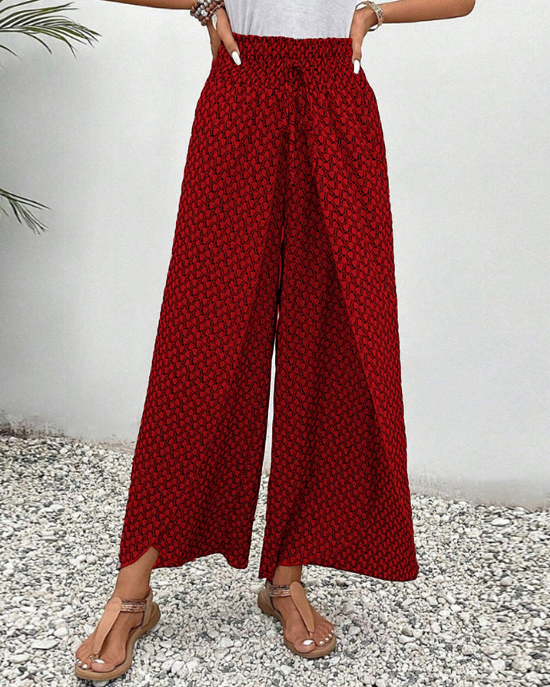 Red wide-leg trousers with shirred waist, repeating micro pattern, full length.