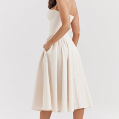 Abito corsetto crema a spalline sottili, gonna a pieghe svasata midi