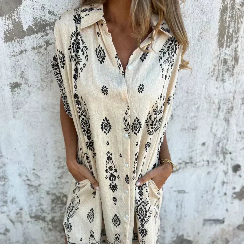 Abito beige stampato con bottoni frontali e maniche ad aletta.