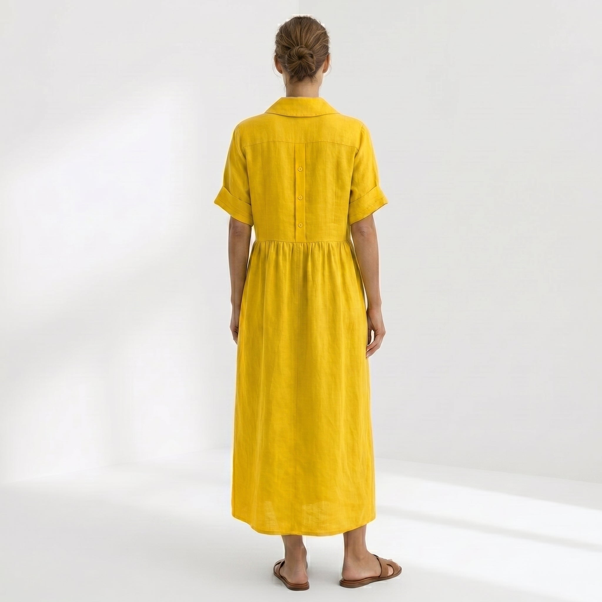 Abito pieghe bottoni giallo con colletto e maniche corte, gonna lunga, vista posteriore
