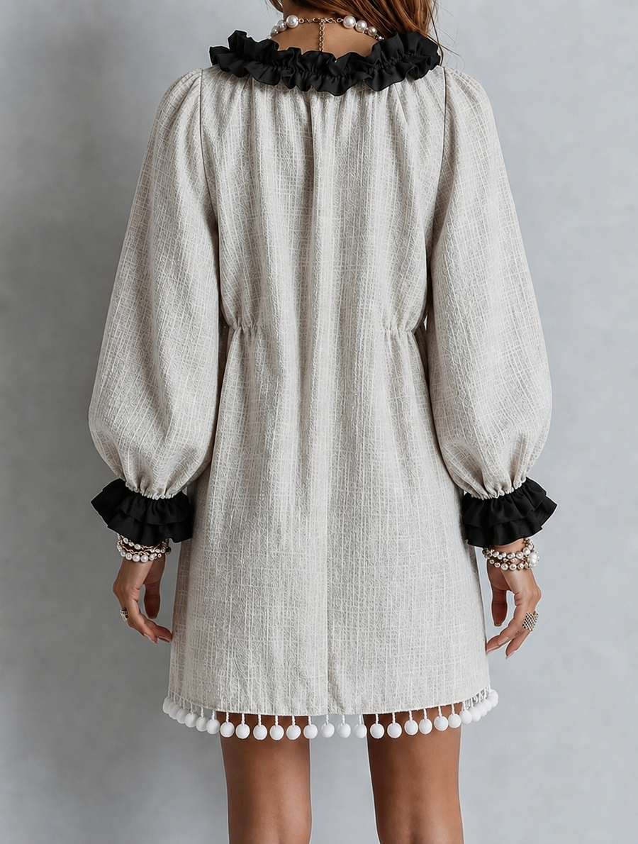 Beige puff-sleeve midi dress with black ruffled cuffs and bottom tassel trim