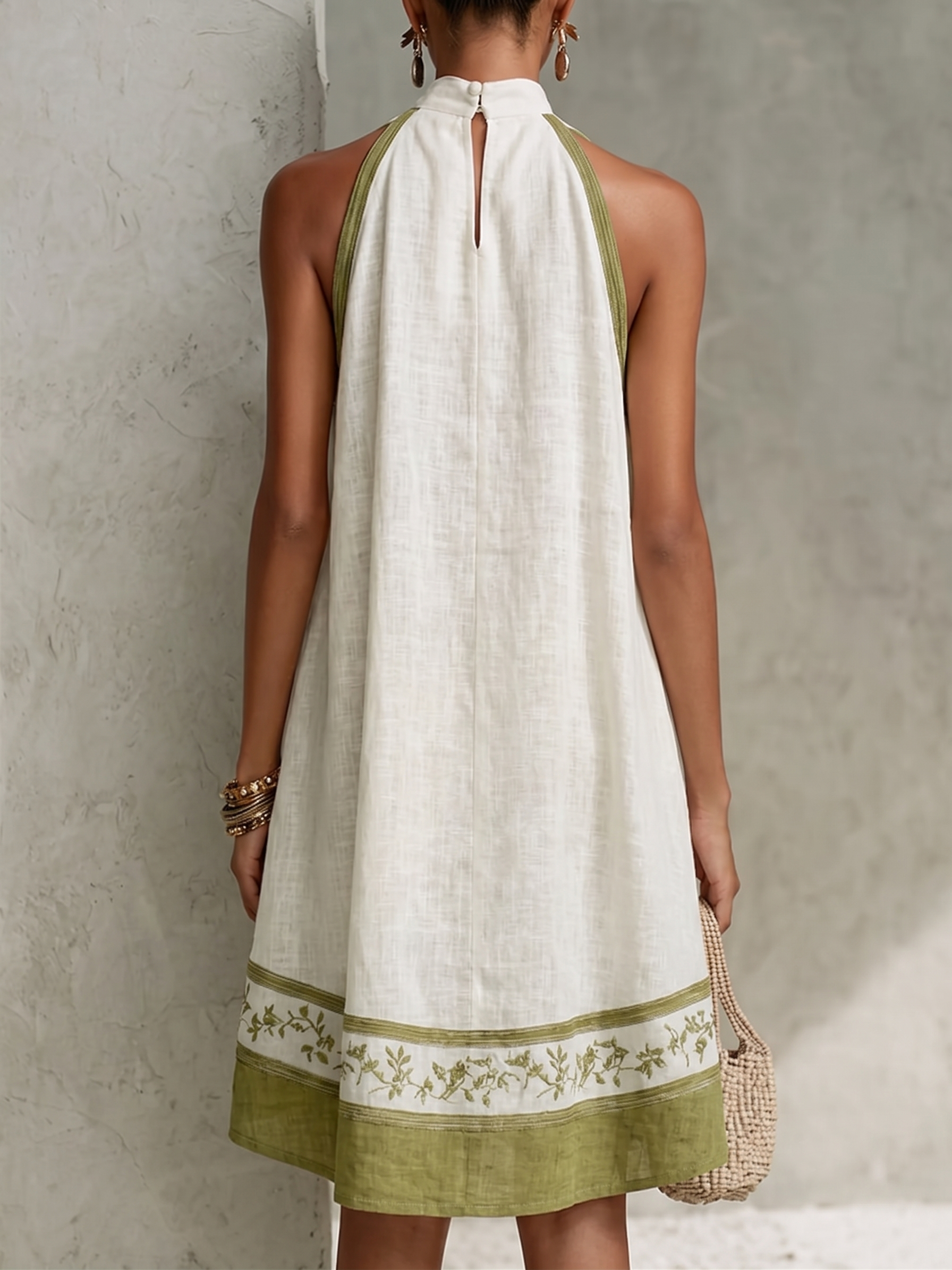 Back view of white halter midi dress with keyhole neck and green floral hem